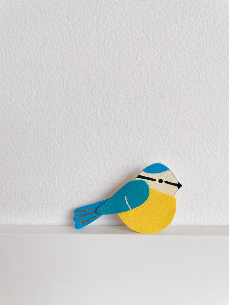 Broche mésange en cuir surcyclé avec dorure à chaud, bijou artisanal inspiré de la nature.