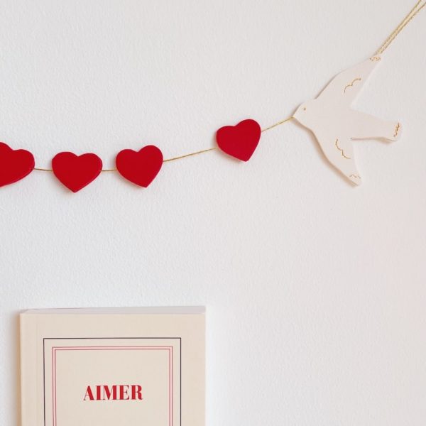 Ribambelle "de l'amour dans l'air". Guirlande décorative pensée comme un bijou mural avec oiseaux blancs aux détails dorés à chaud à l'or véritable et coeurs rouges, roses, poudre, nude, or clair ou or rose selon les modèles. Décoration murale poétique pour l'intérieur. Cet objet décoratif unique permet de sublimer avec élégance et raffinement n'importe quelle pièce de la maison et fait aussi un joli cadeau original de Saint-Valentin, fête des mères, pour un baptême, des fiançailles ou un mariage. Artisanat d'art, façonnage en cuir surcyclé ( excédents de tanneries françaises ennoblis) sur la côte d'Opale, Hauts-de-France