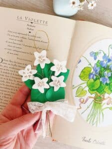 Bijou de mur ou décoration florale d'intérieur au style champêtre légèrement rétro ou vintage. Bouquet de violettes à suspendre et à offrir comme cadeau de mariage, d'amitié, de communion. Cuir surcyclé doré à chaud à l'or véritable, laiton, dentelle ancienne chinée avec amour. Fabrication artisanale. Métiers d'art. Pièces uniques façonnées sur commande et personnalisables.