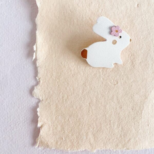 Broche lapin en cuir upcyclé fait main, aux lignes épurées et ornée de détails dorés à chaud. Un petit cadeau adorable, idéal pour Pâques, pour les amoureux de littérature ou pour porter chance