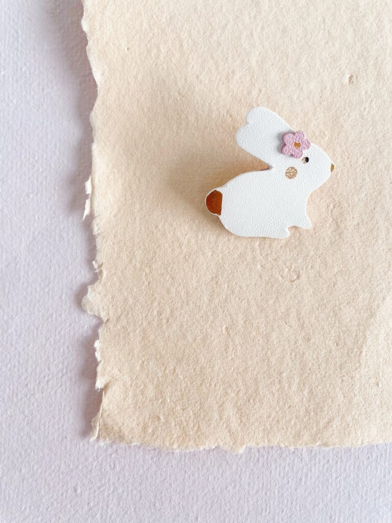 Broche lapin en cuir upcyclé fait main, aux lignes épurées et ornée de détails dorés à chaud. Un petit cadeau adorable, idéal pour Pâques, pour les amoureux de littérature ou pour porter chance