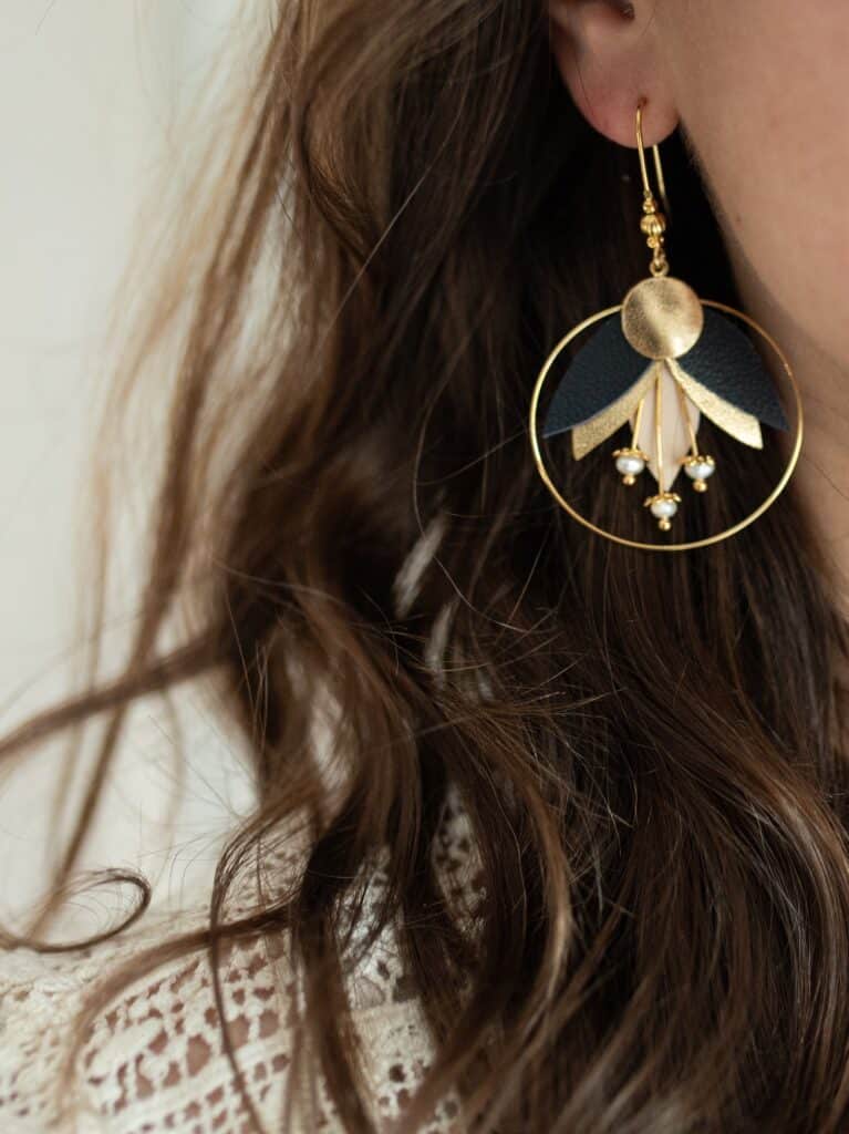 Boucles d’oreilles en cuir surcyclé, inspirées de la fleur de colchique avec détails dorés.