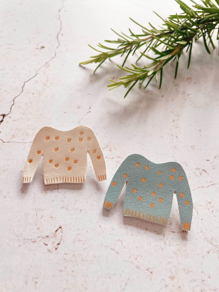 Broches en cuir en forme de pull miniature décoré de flocons, avec dorure à chaud.