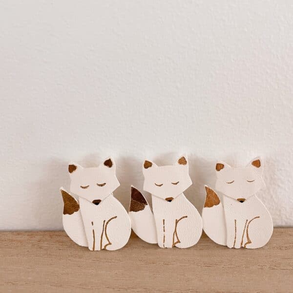 Trois broches renard blanches dorées montrant de légères variations artisanales