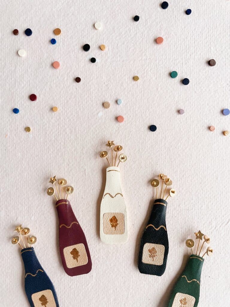 Broche bouteille de champagne artisanale en cuir avec bulles dorées