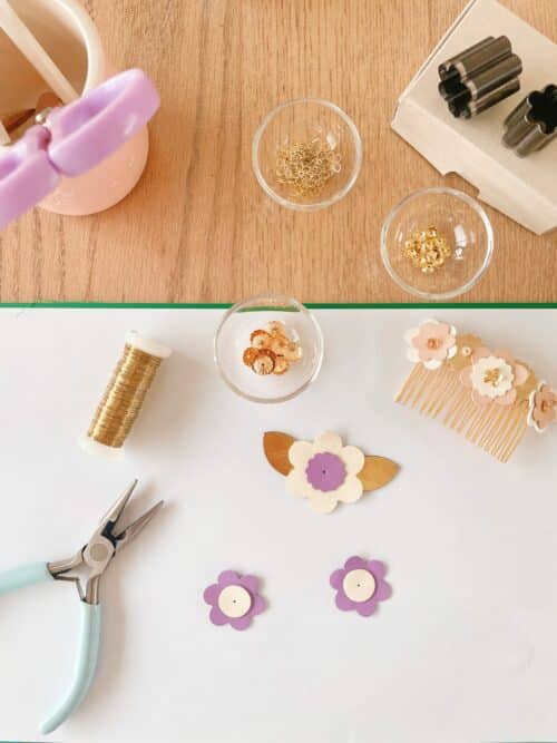 Fleurs en cuir, pinces et apprêts disposés sur une table d’atelier.