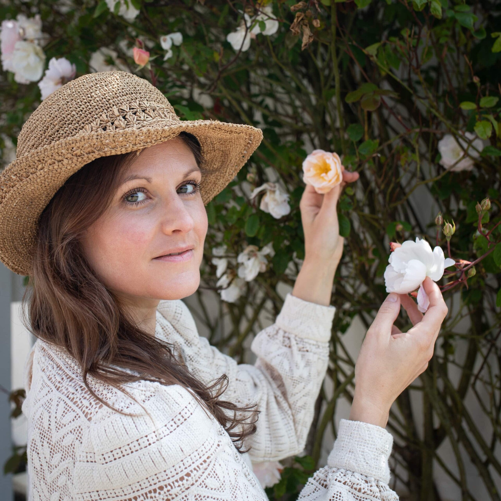 Portrait de Camille Doutriaux-Poulet devant un rosier fleuri.